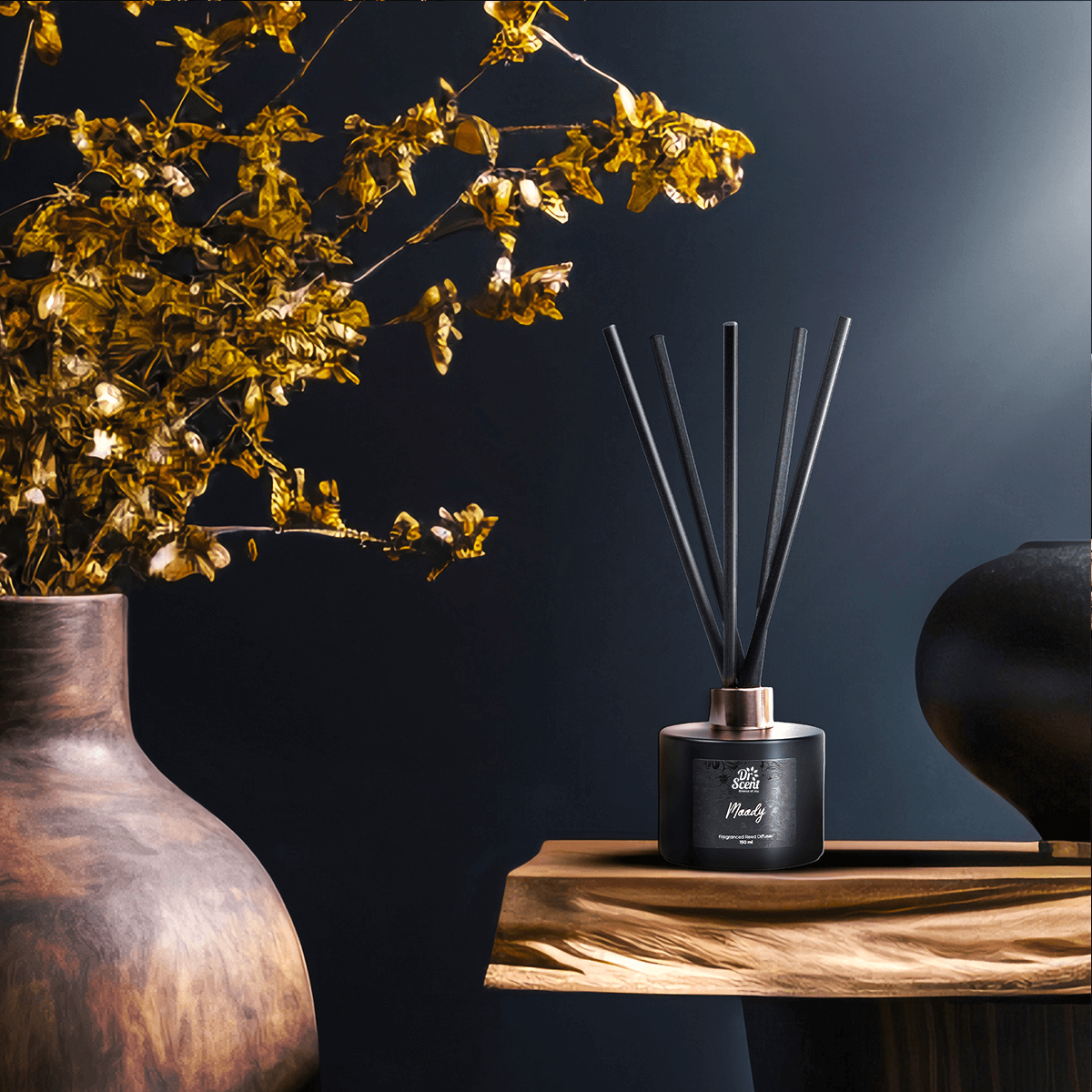 Moody reed diffuser beside a vase of yellow flowers