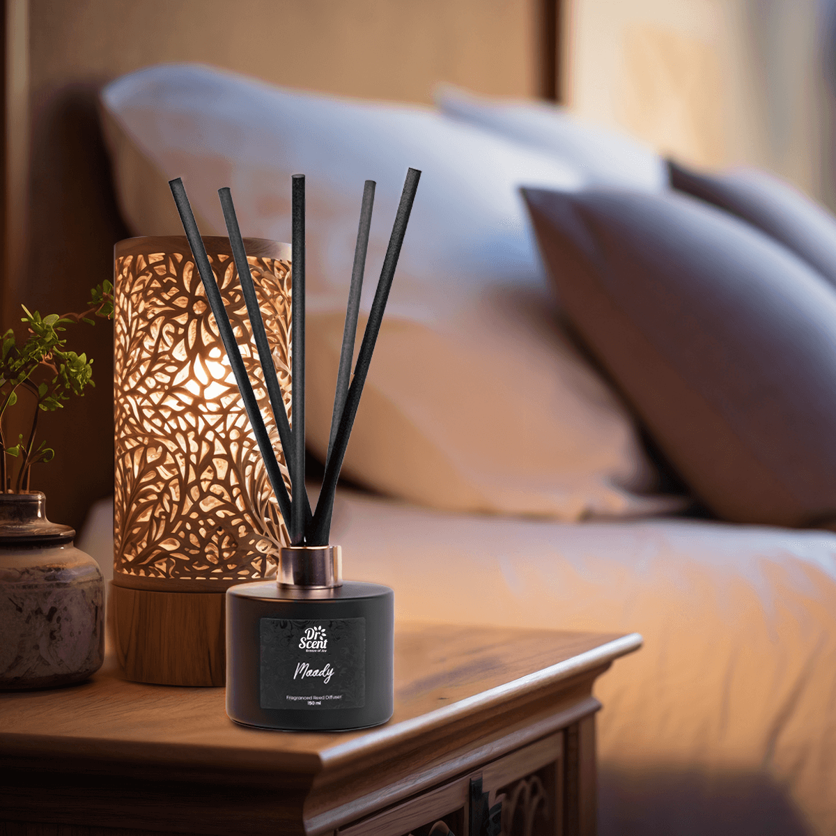 Moody reed diffuser on a bedroom side table next to a lamp
